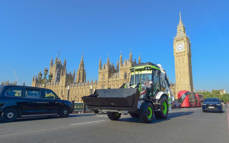 JCB idrogeno a Londra: La terna JCB a idrogeno percorre Westminster Bridge davanti al Parlamento e al Big Ben, celebrando l’approvazione della legge che consente la circolazione su strada delle macchine operatrici alimentate a idrogeno nel Regno Unito