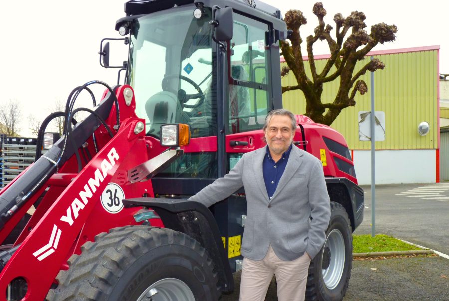 Jon Lopez davanti a una macchina compatta Yanmar durante una visita aziendale.