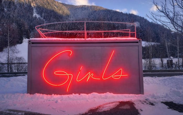 Artcontainer GIRLS WANTED con scritta luminosa rossa installato ad Anterselva durante i Giochi Olimpici Invernali di biathlon.